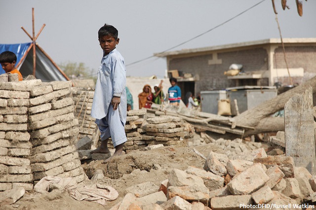 A child stands amongst the remains of buildings destroyed by the floods in Sindh province, Pakistan