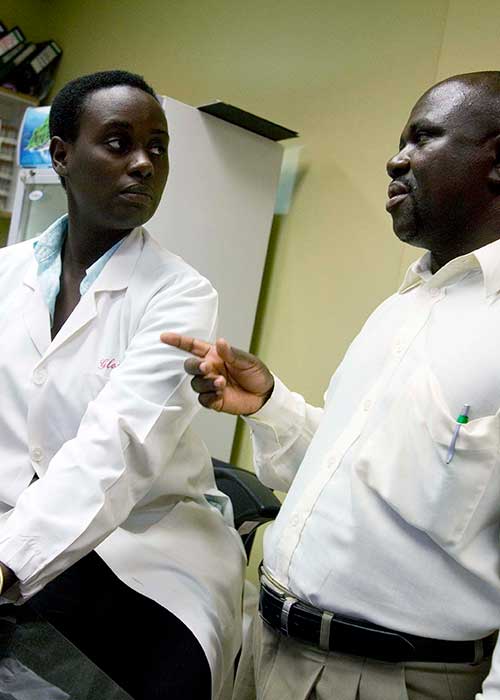 Man talking to lab technician, Kampala, Uganda